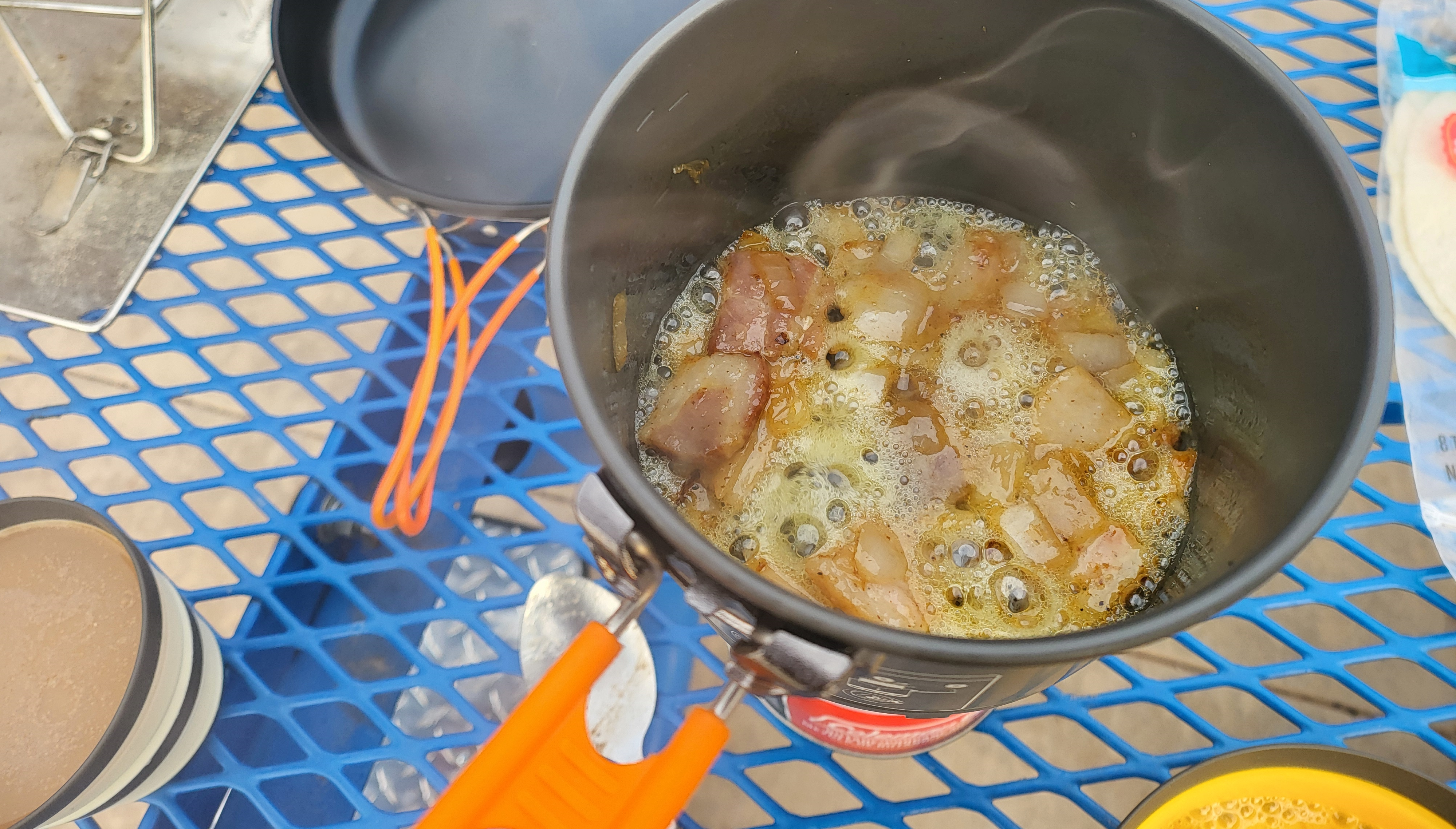 Using the JetBoil Stash to sauté bacon and onions.