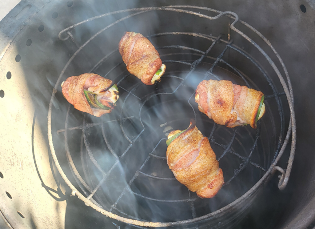 Four smoked jalapeno poppers cooked to a golden brown on The Big Easy grill.